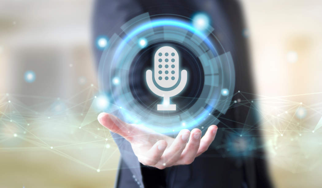 Montage: Eine Hand hält ein schwebendes, leuchtendes Mikrofon-Symbol mit digitalen Netzwerklinien